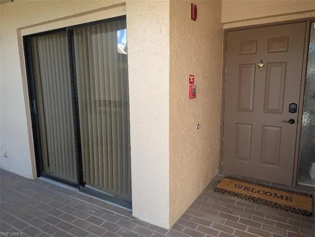 Doorway to property featuring stucco siding