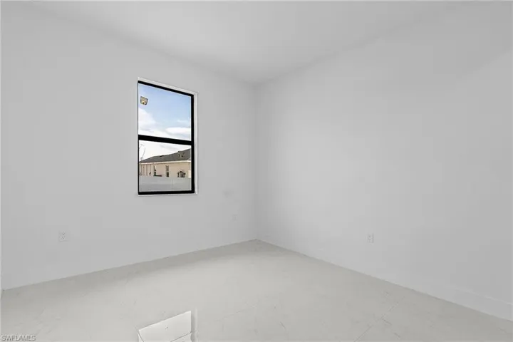 Spare room featuring marble finish floor and baseboards