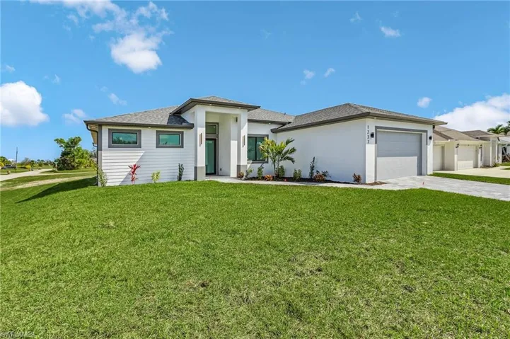 Prairie-style house with a front yard, concrete driveway, and a garage