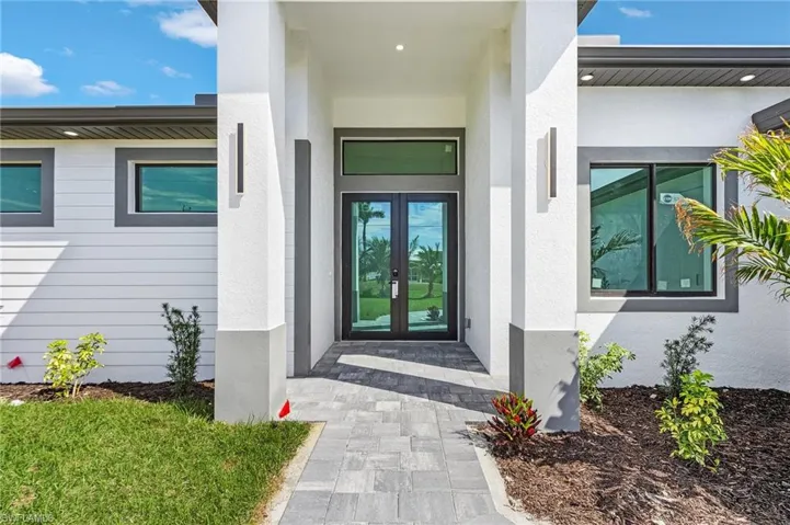 Property entrance featuring stucco siding and french doors