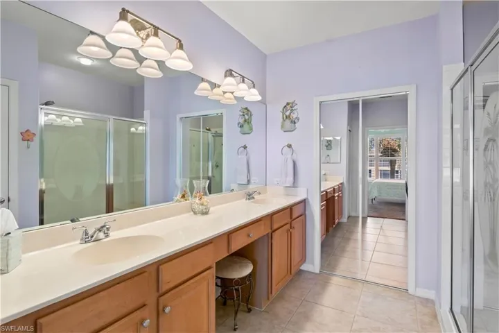 The primary suite features a double vanity with plenty of counter and cabinet space, as well as a walk-in shower.