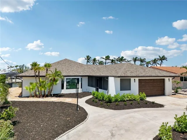 Ranch-style house with stucco siding, an attached garage, and driveway
