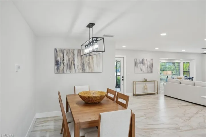 Dining area featuring light marble finish floors, recessed lighting, and baseboards