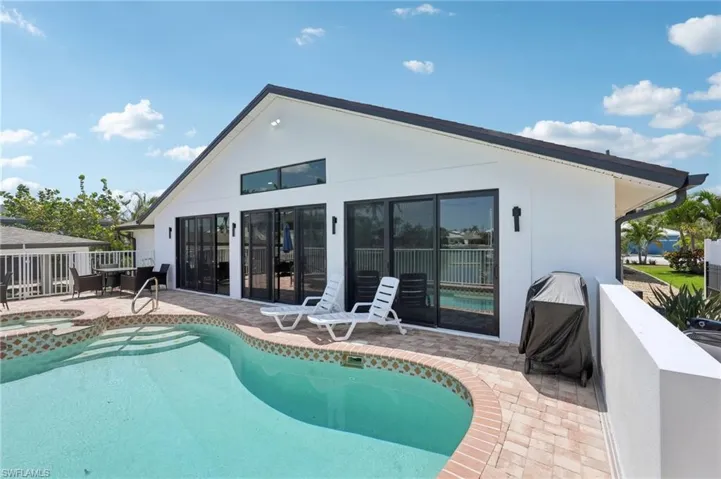 View of pool with a patio area and a pool with connected hot tub