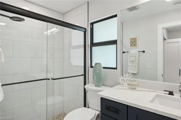 Bathroom with toilet, a shower stall, and vanity