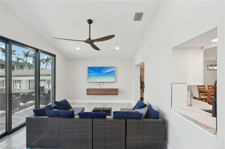 Living room with vaulted ceiling, a ceiling fan, recessed lighting, and baseboards