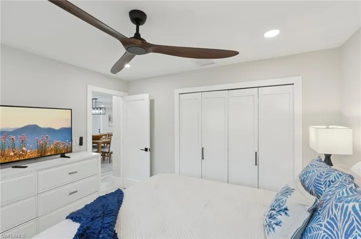 Bedroom with recessed lighting, ceiling fan, a closet, and light marble finish floors