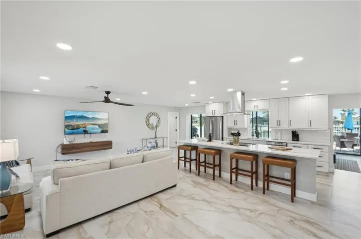 Living area featuring recessed lighting, a ceiling fan, and light marble finish floors