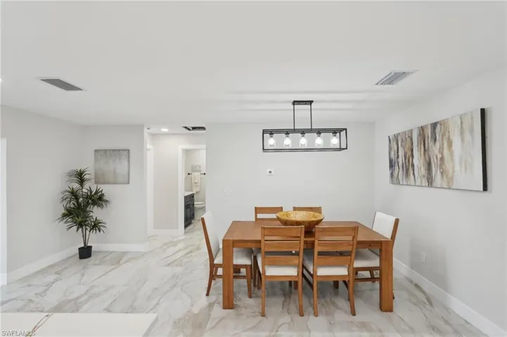 Dining area featuring light marble finish flooring, baseboards, and recessed lighting