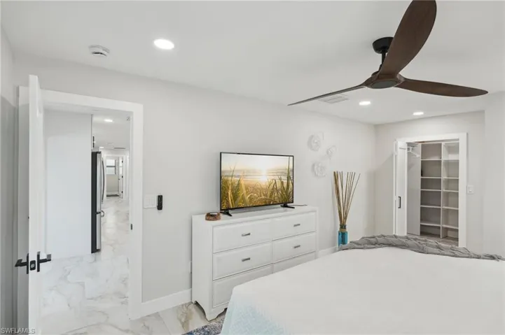 Bedroom with light marble finish floors, freestanding refrigerator, recessed lighting, baseboards, and a ceiling fan