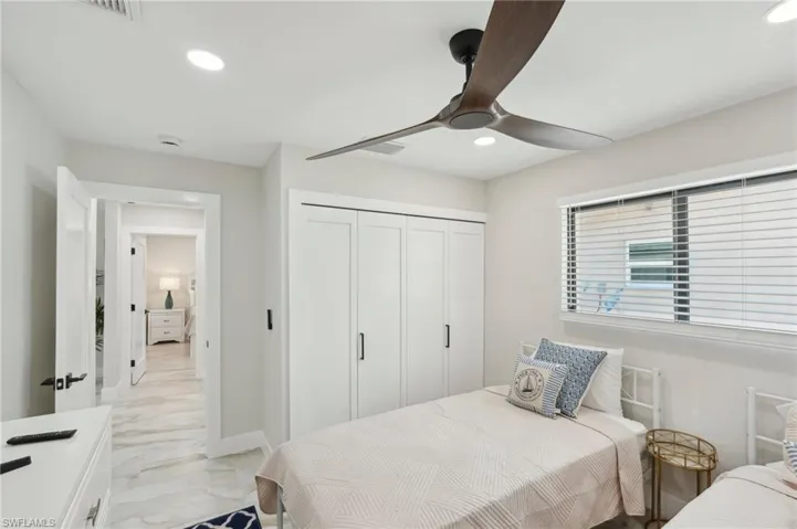 Bedroom with recessed lighting, light marble finish floors, a closet, a ceiling fan, and baseboards