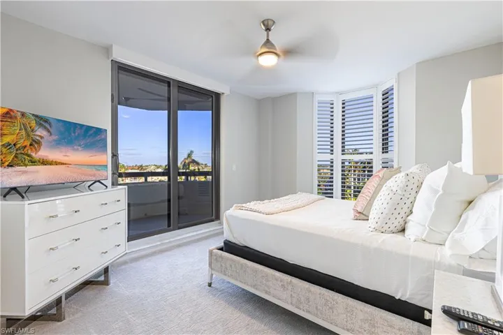 Bedroom with access to exterior, light colored carpet, and ceiling fan