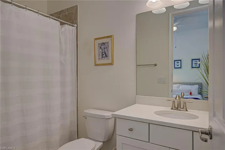 Full bath with vanity, a shower with curtain, and a ceiling fan