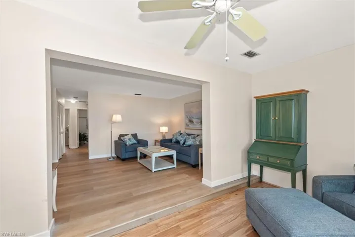 Living area with light wood-type flooring and ceiling fan