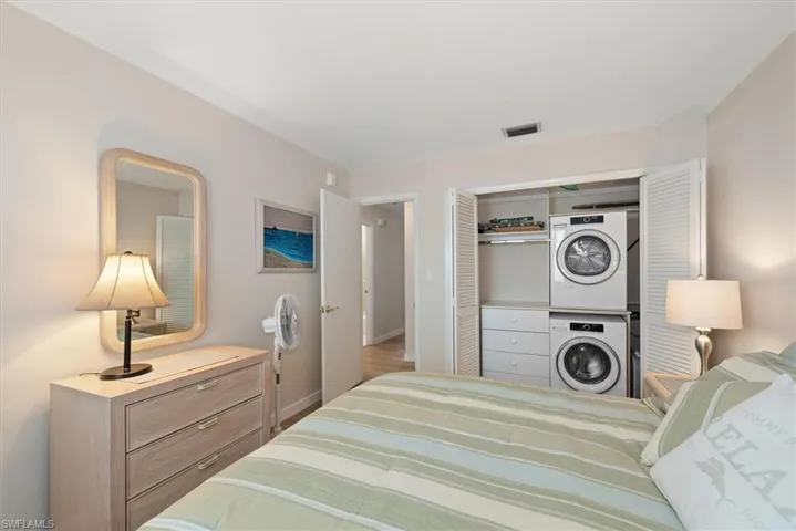 Bedroom featuring stacked washer / dryer and a closet