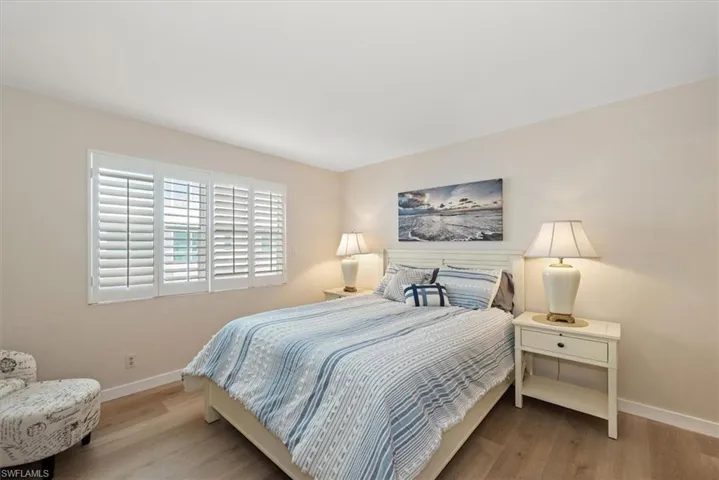 Bedroom with wood finished floors and baseboards