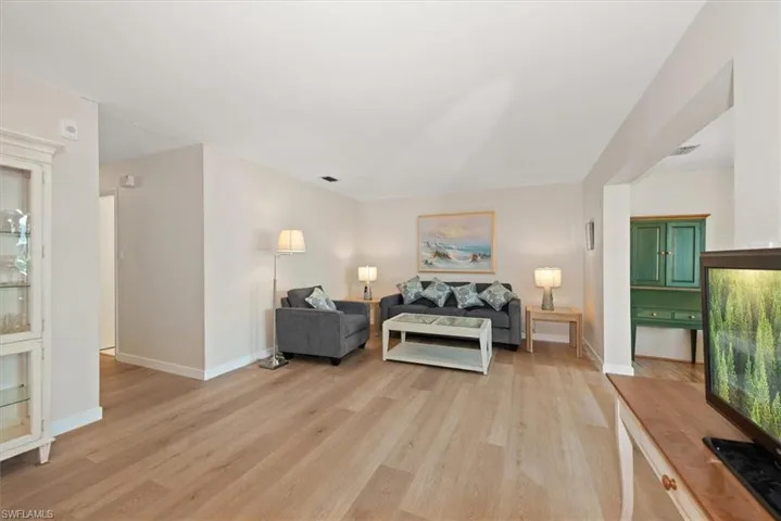 Living room with light wood-style floors - view from dining room