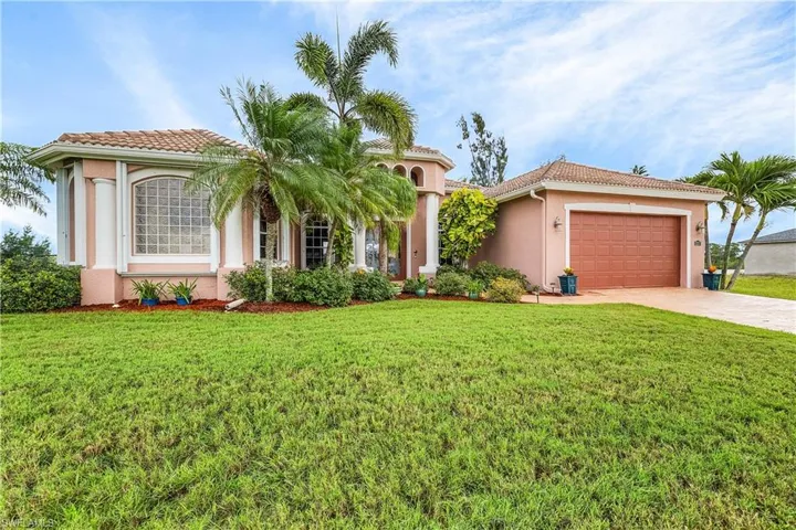 Mediterranean concept with stucco, a front lawn, and an attached two-car garage