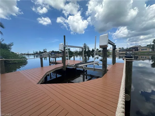 Dock area featuring boat lift and a water view