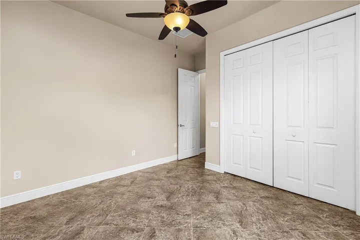 Bedroom featuring a closet, a ceiling fan, and tile flooring