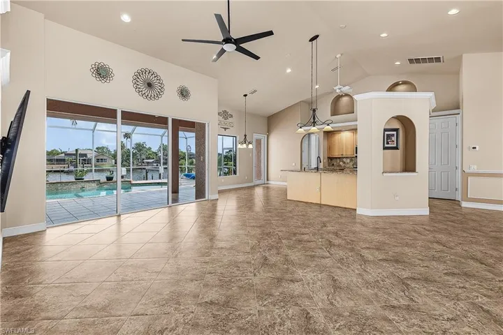 Living room with a ceiling fan, high vaulted ceiling, healthy amount of natural light, and recessed lighting