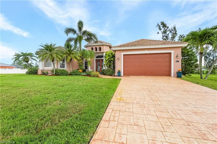 Mediterranean / spanish-style home with a garage, decorative driveway, stucco siding, and a tile roof