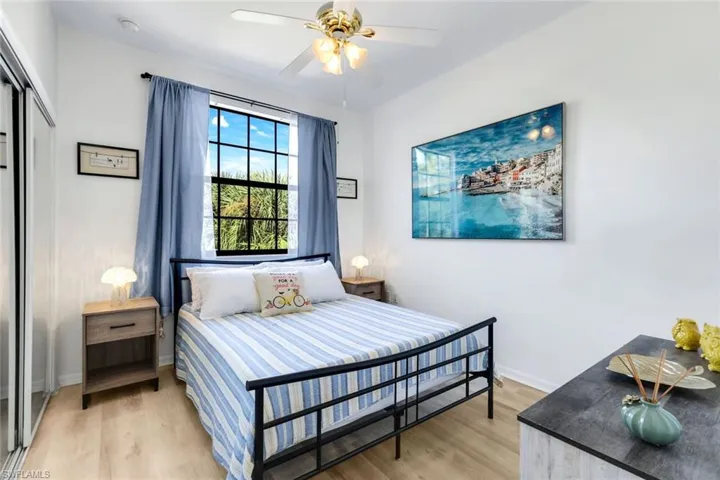 Bedroom with light wood-style flooring, a closet, and ceiling fan