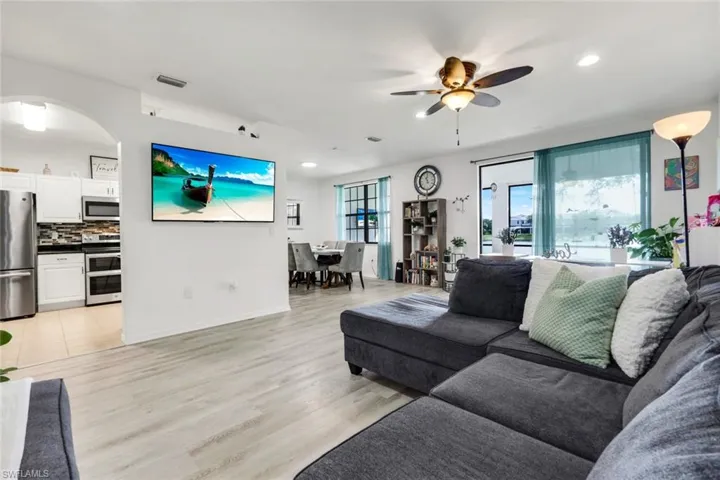 Living area with light wood finished floors, ceiling fan, and recessed lighting