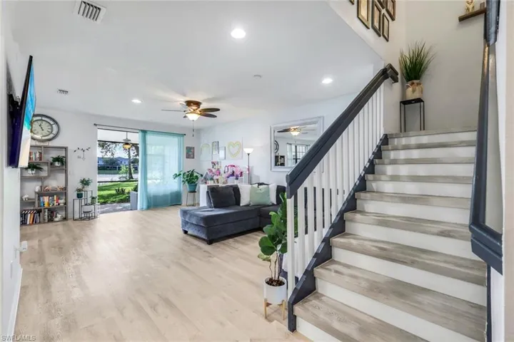 Stairway with wood finished floors, recessed lighting, and a ceiling fan