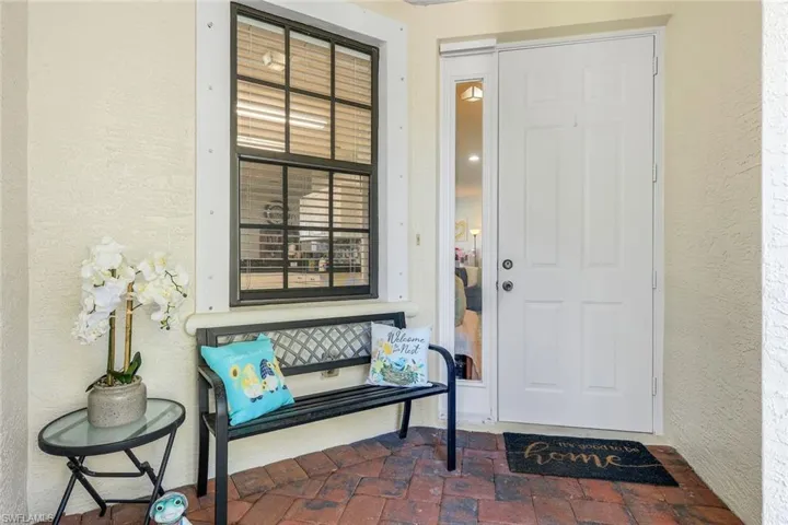 Entrance to property with stucco siding and a patio