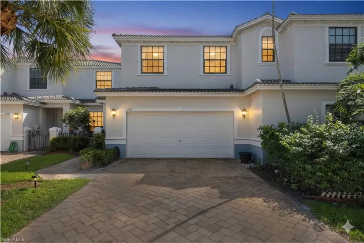 Mediterranean / spanish-style home featuring decorative driveway, an attached garage, a tile roof, and stucco siding