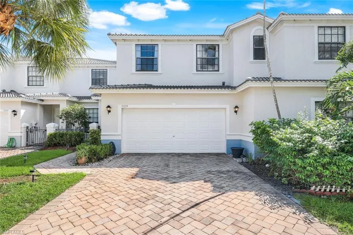 Mediterranean / spanish house with decorative driveway, an attached garage, stucco siding, and a tile roof