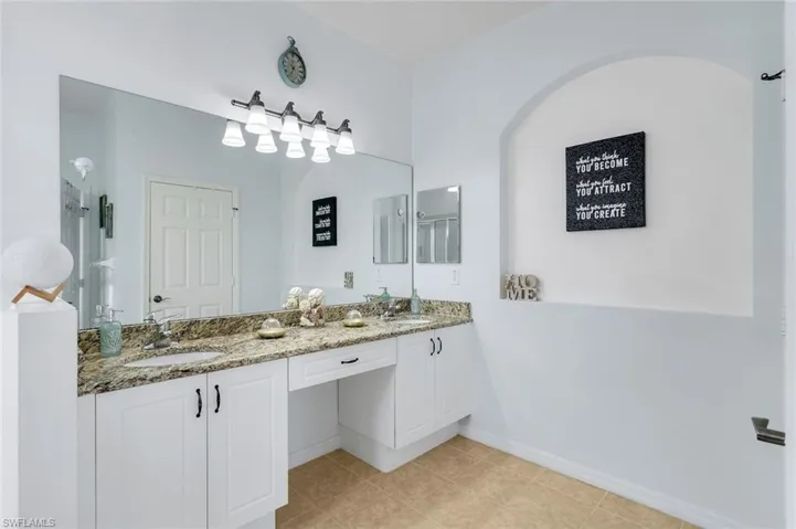 Full bath with double vanity and light tile patterned flooring