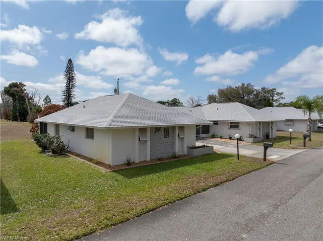 Ranch-style home with a front yard and a shingled roof