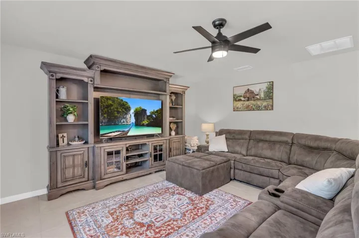 Living room with ceiling fan and light tile patterned floors