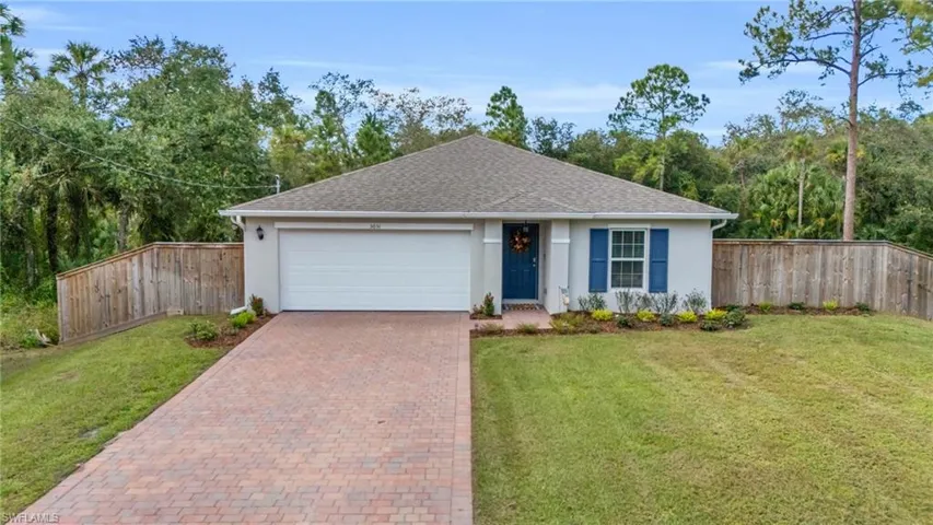Ranch-style home with a garage and a front lawn