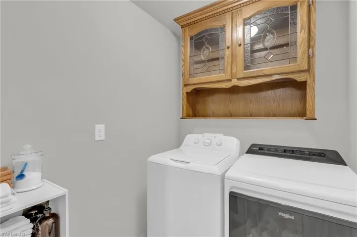 Laundry room featuring washing machine and clothes dryer and cabinets