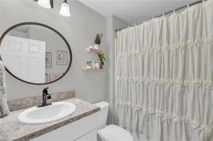 Bathroom featuring vanity, toilet, and a shower with curtain