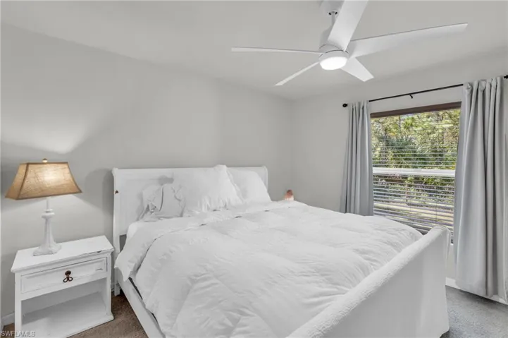 Bedroom with dark carpet and ceiling fan