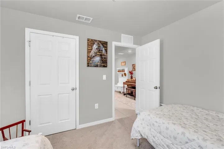 Bedroom with light carpet and a closet
