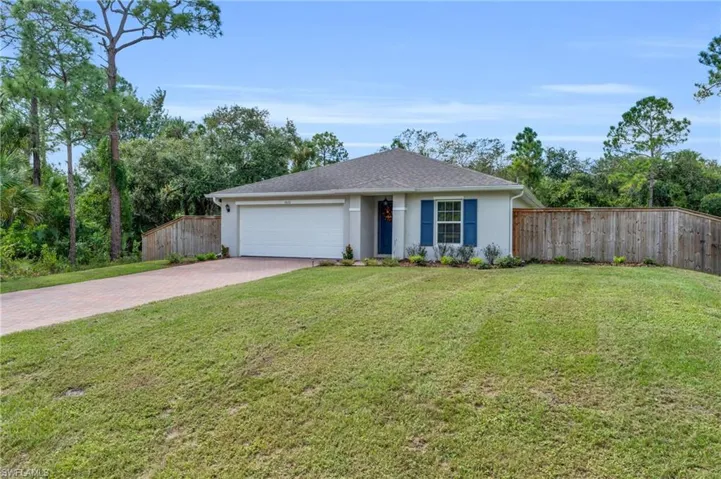 Single story home featuring a front yard and a garage