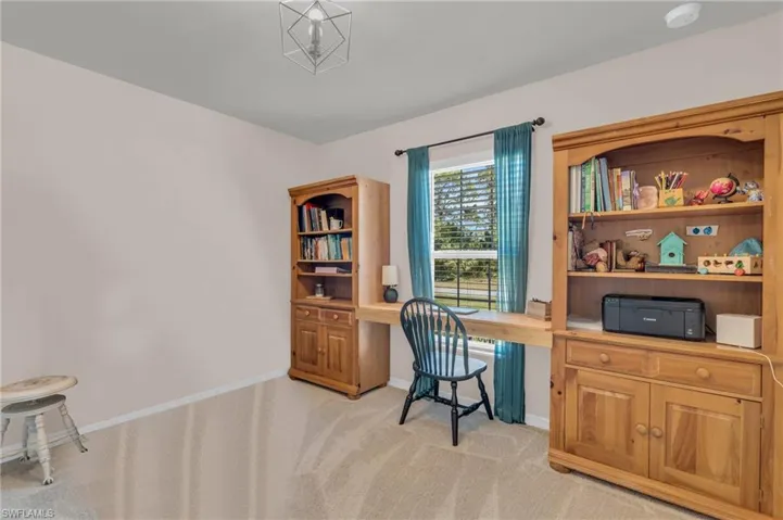Carpeted home office with built in desk