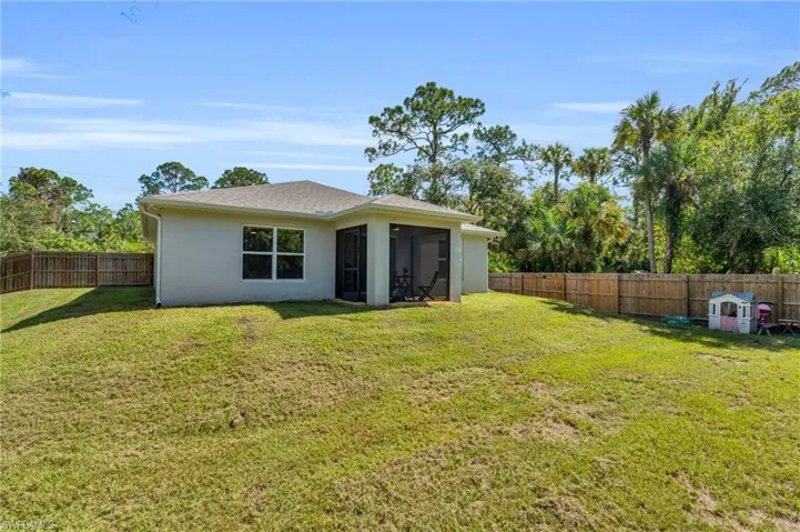 Back of property featuring a sunroom and a lawn