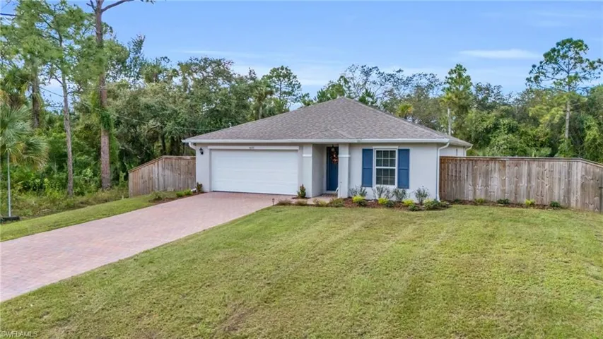 Ranch-style home featuring a garage and a front lawn
