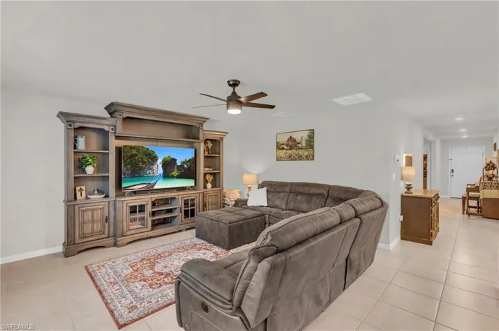 Living room featuring ceiling fan and light tile patterned floors
