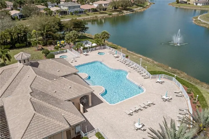 Community pool featuring a patio area, a water view, and a residential view