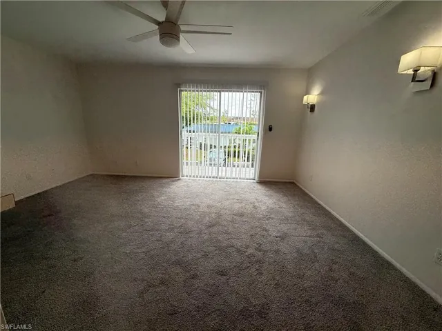 Empty room with a ceiling fan, carpet, and baseboards