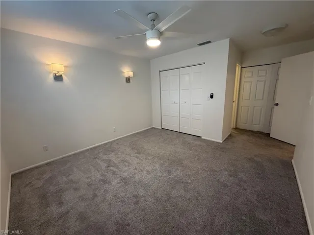 Unfurnished bedroom featuring carpet, baseboards, and a ceiling fan