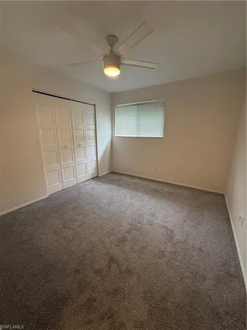 Unfurnished bedroom with carpet floors, a closet, and baseboards
