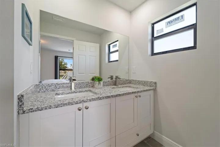 Full bathroom featuring double vanity and baseboards